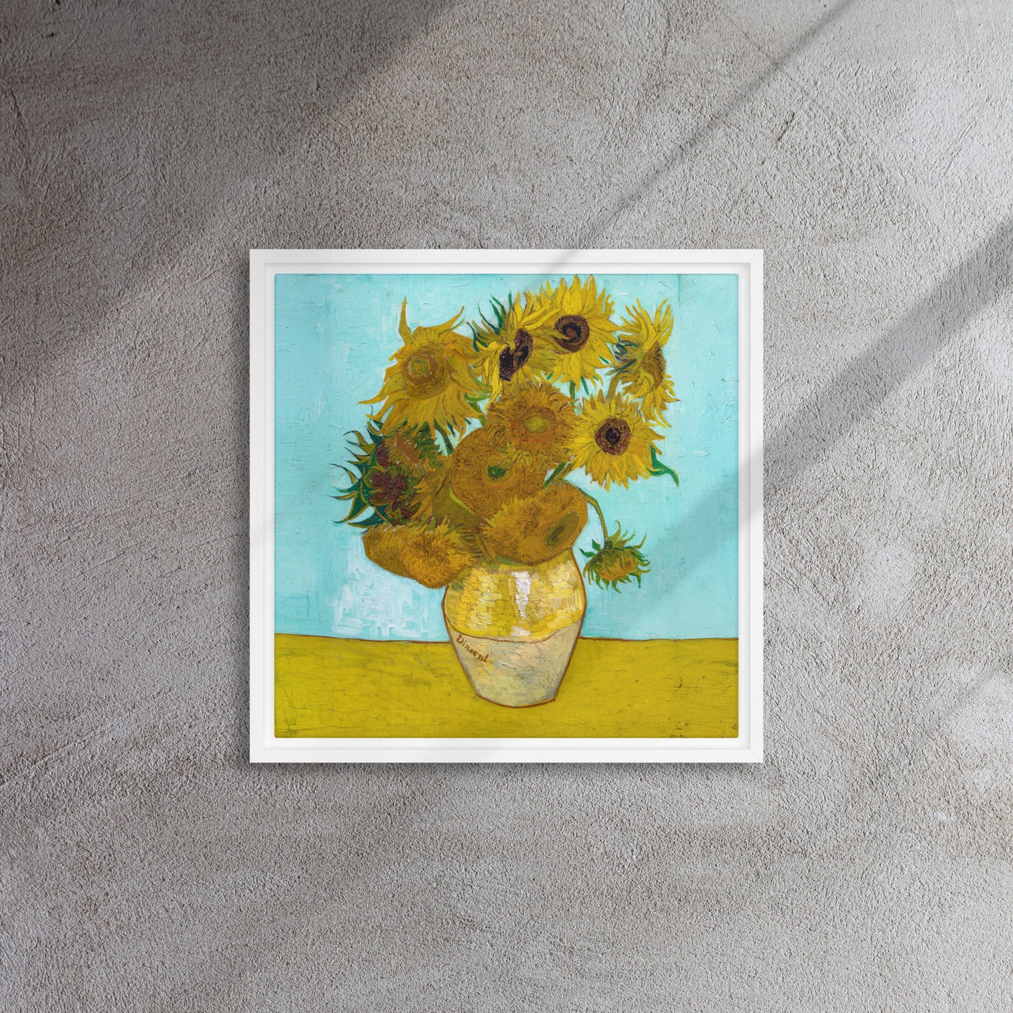 Van Gogh's 'Vase with Twelve Sunflowers' on a 16"x16" white framed canvas print on a textured wall.