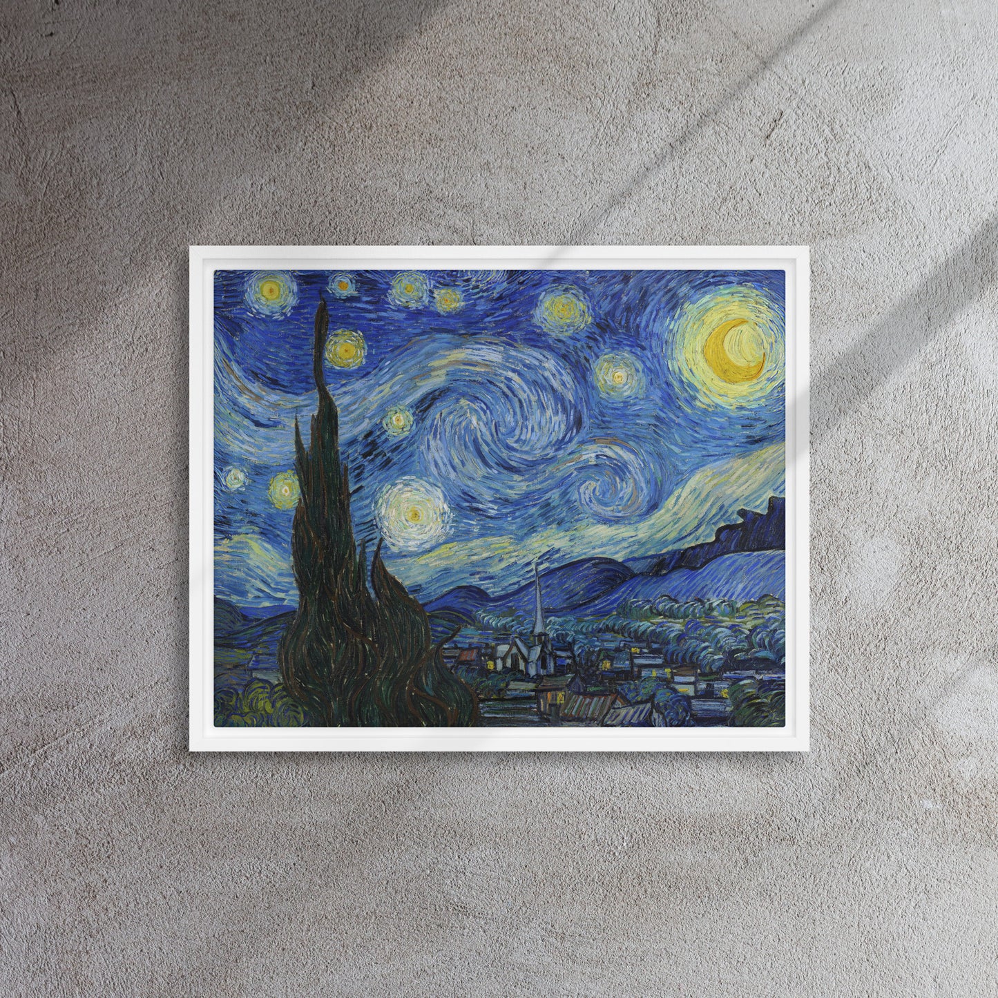 Van Gogh's 'Starry Night' on a 16"x20" white framed canvas print on a textured gray wall.