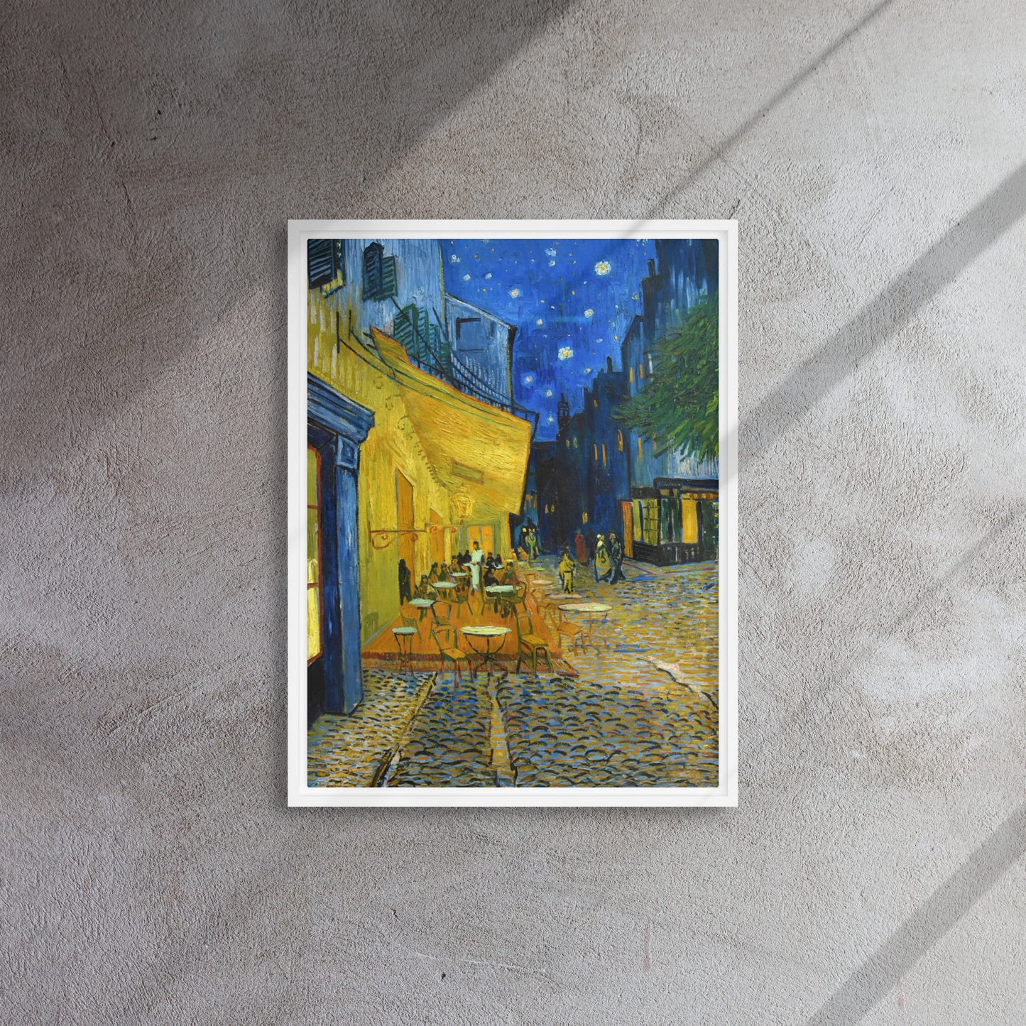 Van Gogh's 'Café Terrace at Night' on a 18"x24" white framed canvas print on a textured gray wall.
