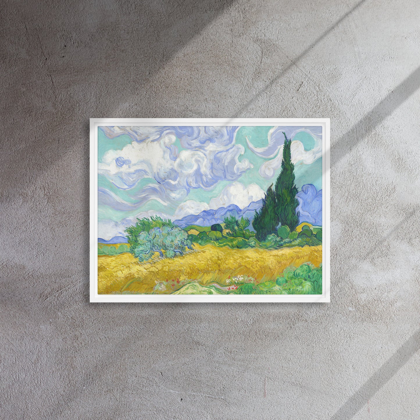 Van Gogh's 'Wheat Field with Cypresses' on a 18"x24" white framed canvas print on a textured gray wall.