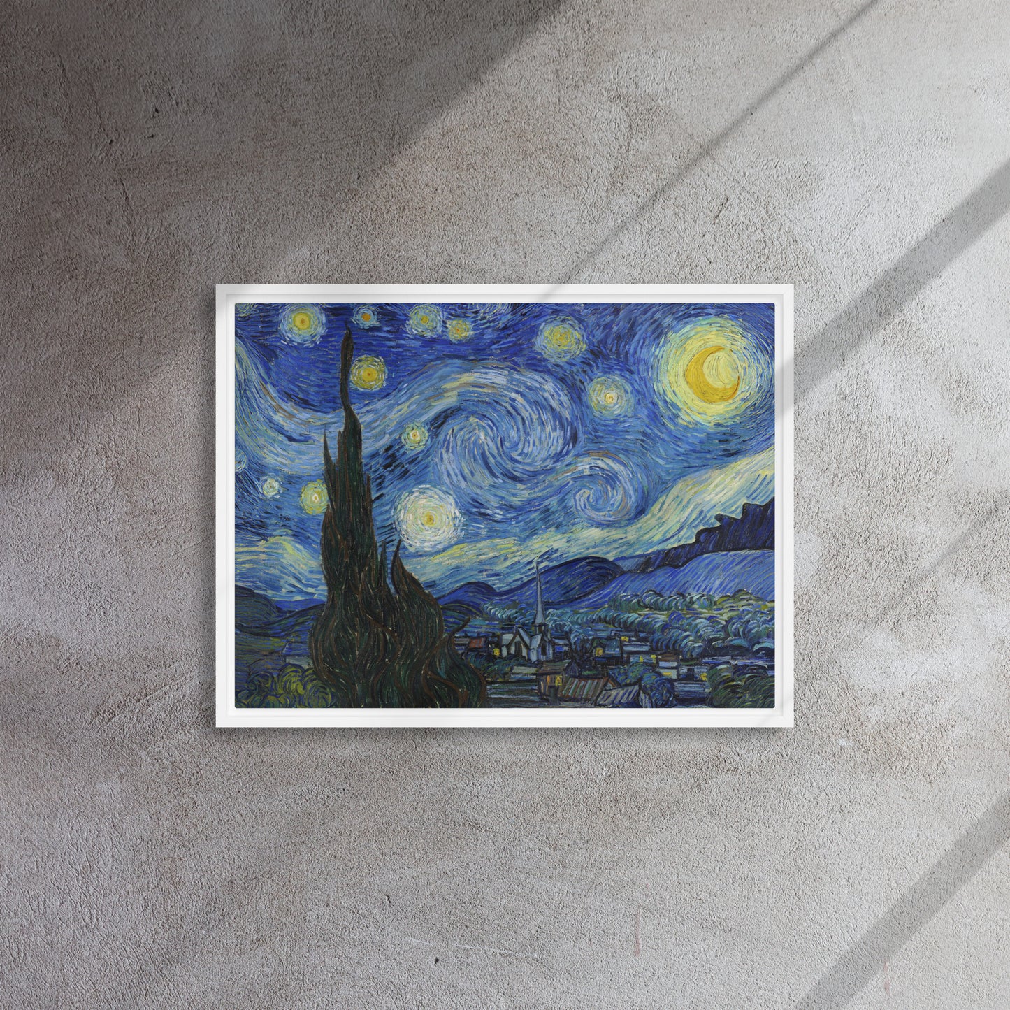 Van Gogh's 'Starry Night' on a 18"x24" white framed canvas print on a textured gray wall.