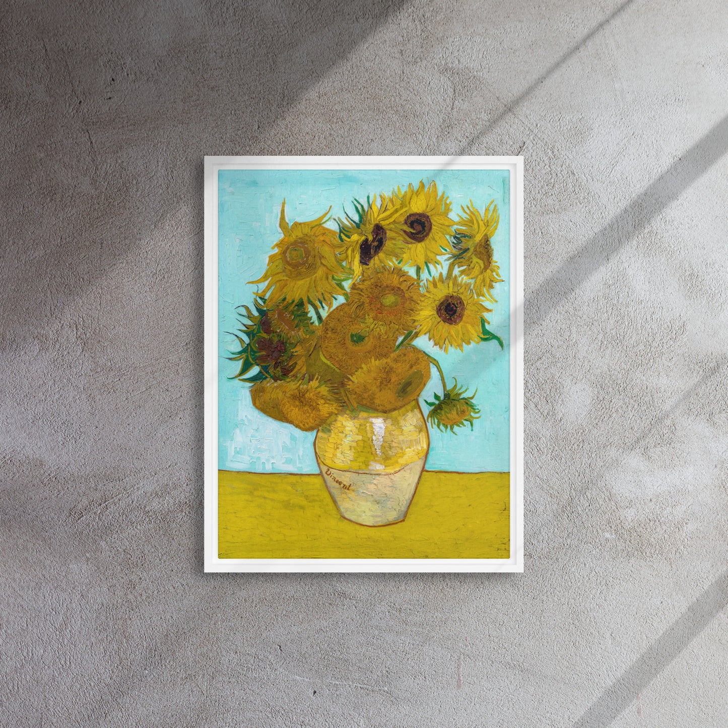 Van Gogh's 'Vase with Twelve Sunflowers' on a 18"x24" white framed canvas print on a textured wall.