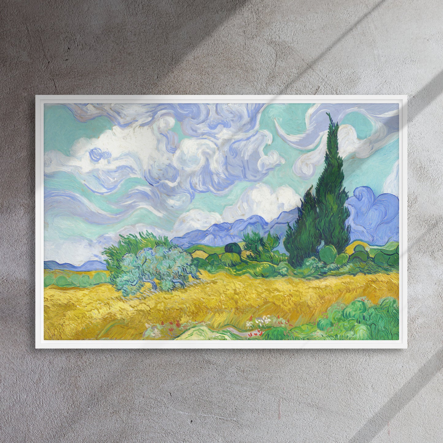 Van Gogh's 'Wheat Field with Cypresses' on a 24"x36" white framed canvas print on a textured gray wall.