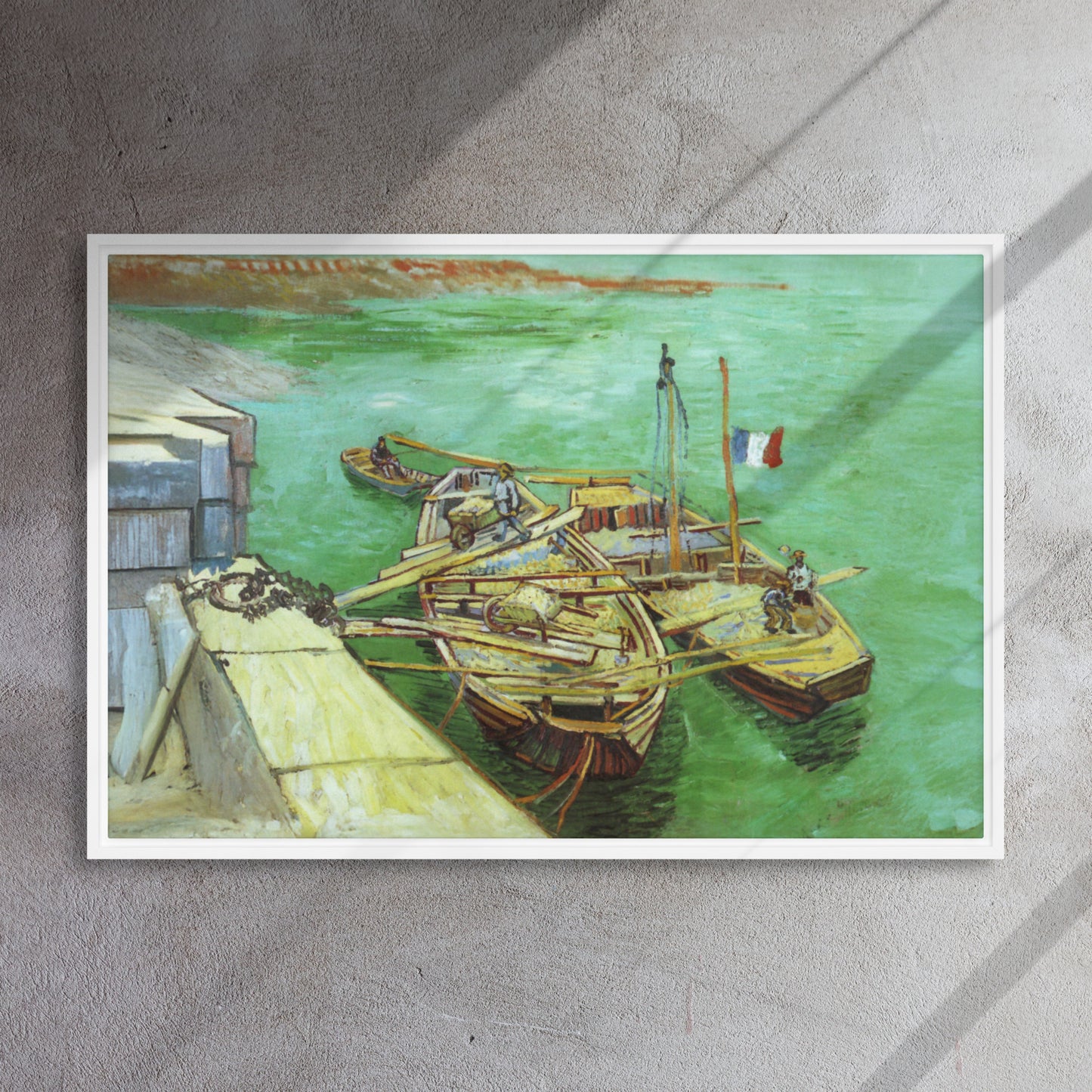 Van Gogh's 'Quay with Men Unloading Sand Barges' on a 24"x36" white framed canvas print on a textured gray wall.