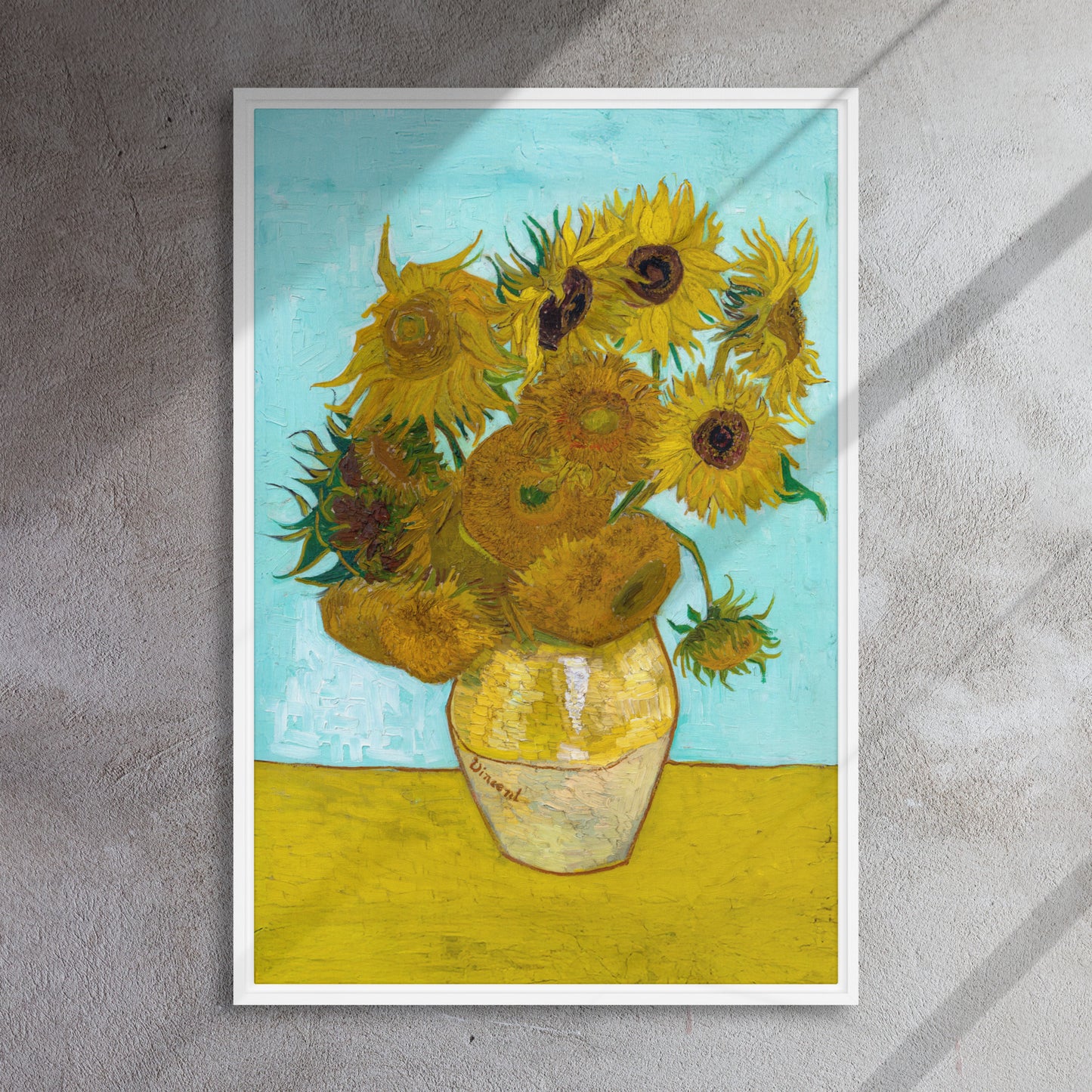 Van Gogh's 'Vase with Twelve Sunflowers' on a 24"x36" white framed canvas print on a textured gray wall.