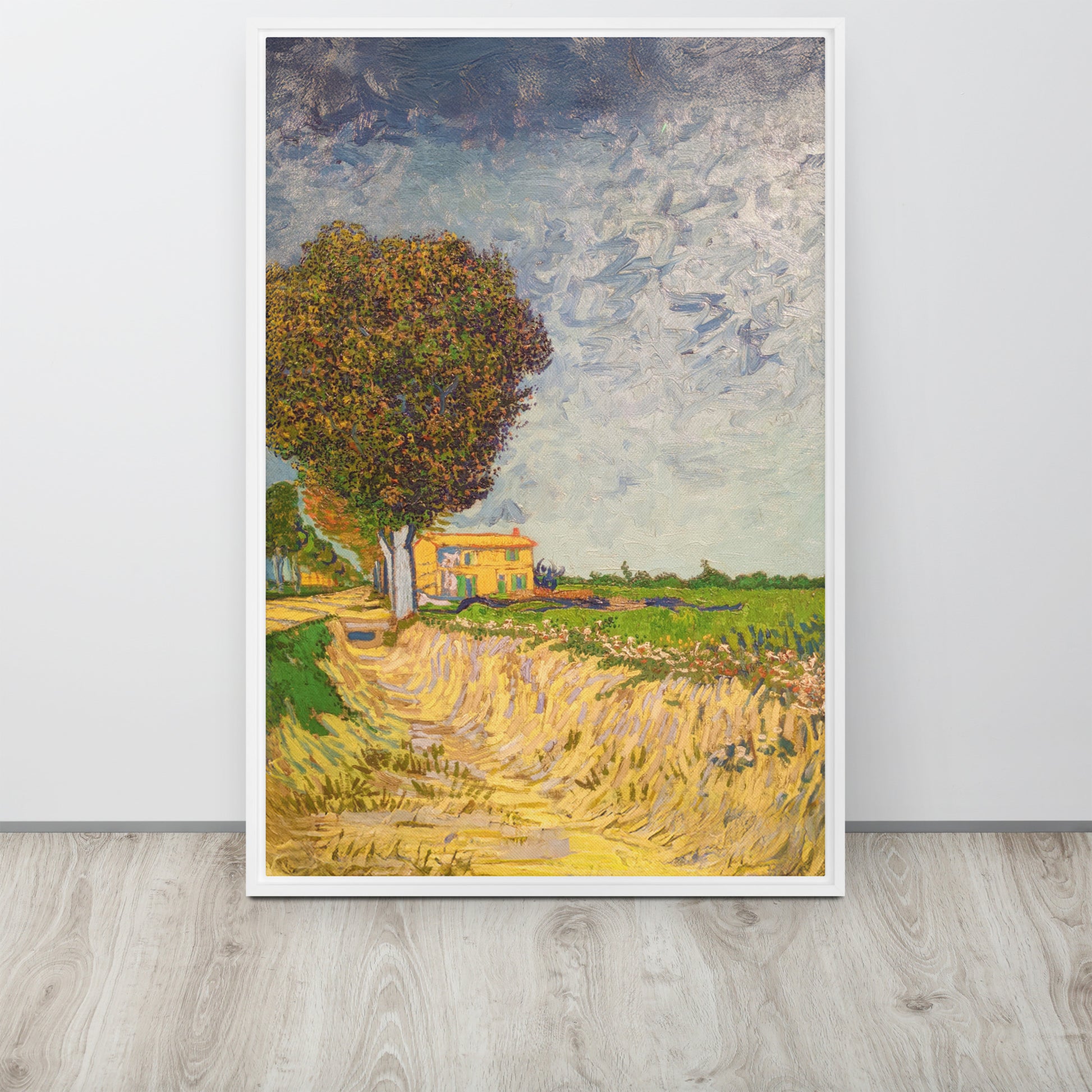Van Gogh's 'A Lane near Arles' on a 24"x36" white framed canvas print sitting on a wooden floor leaning against a light gray wall.