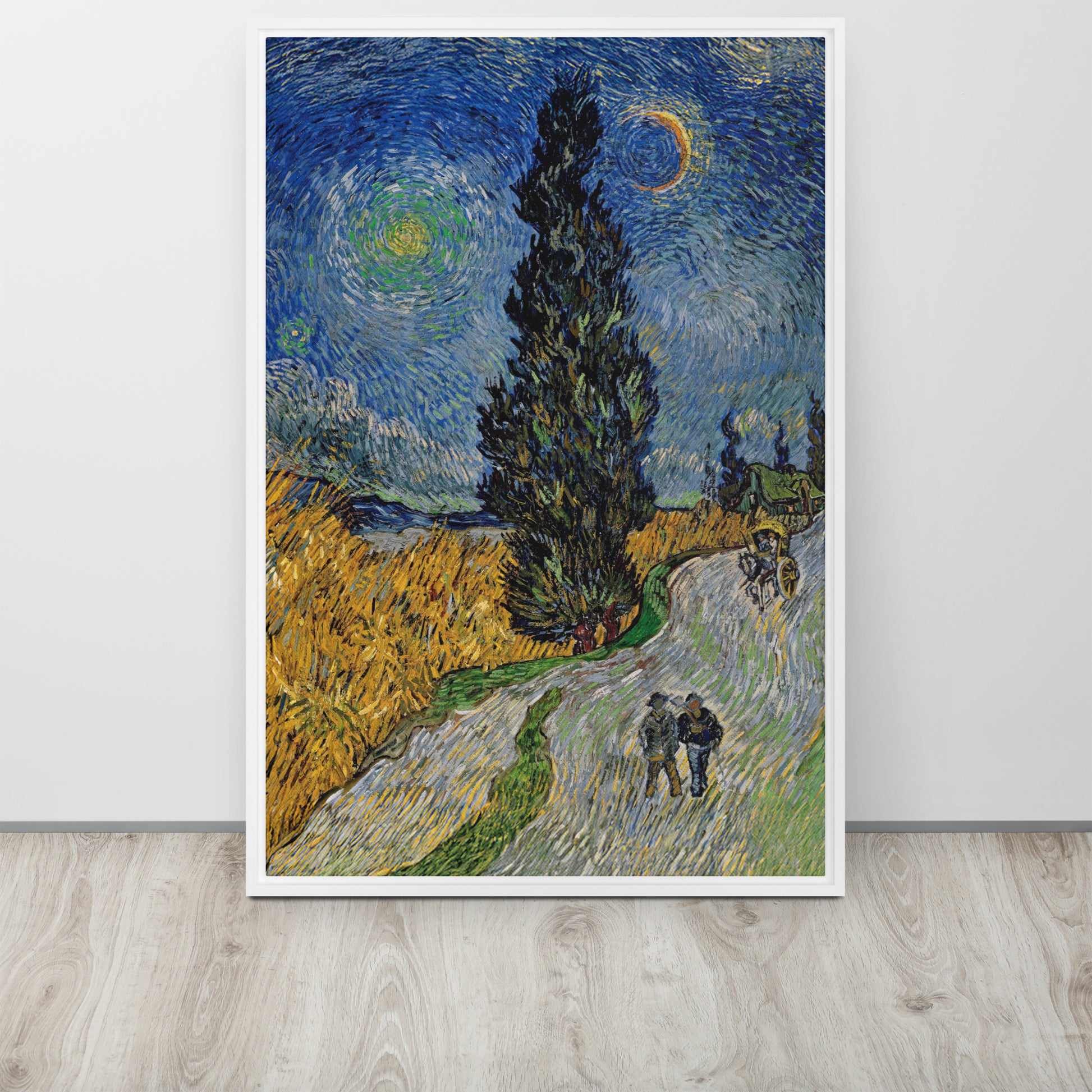 Van Gogh's 'Road with Cypress and Star' on a 24"x36" white framed canvas print sitting on a wooden floor leaning against a light gray wall.
