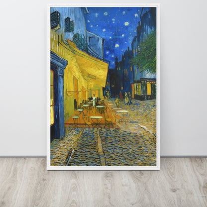 Van Gogh's 'Café Terrace at Night' on a 24"x36" white framed canvas print sitting on a wooden floor leaning against a light gray wall.