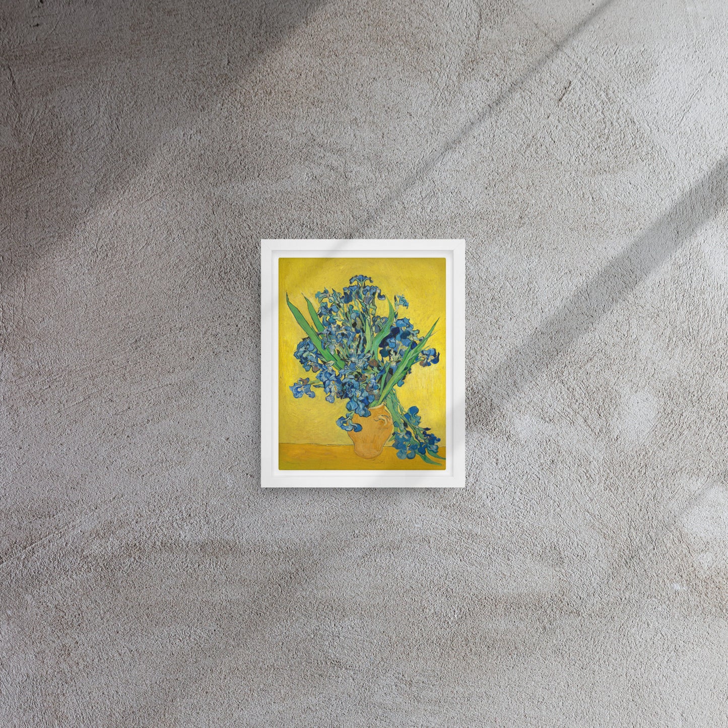 Van Gogh's 'Vase with Irises Against a Yellow Background' on a 8"x10" white framed canvas print on a textured gray wall.